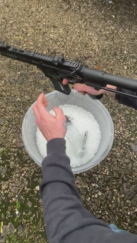 video of the slr cqb with orange tip shooting gel bel balls at a metal target outside.